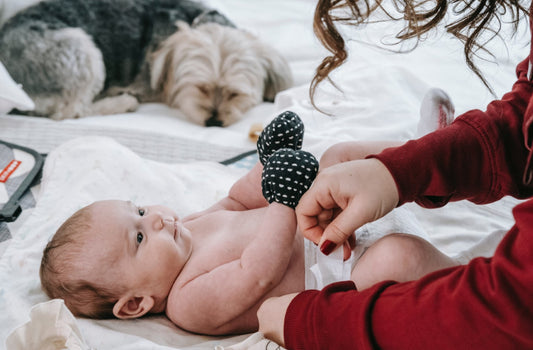 Faceless mother changing baby’s diaper