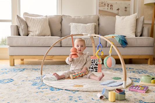 Baby playing in a play gym with toys