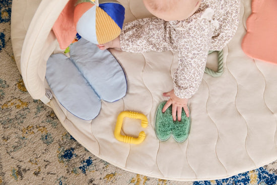 A baby playing with the sensory rich play mat
