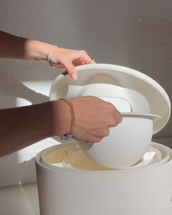 Person taking the bowl out of the potty for cleaning