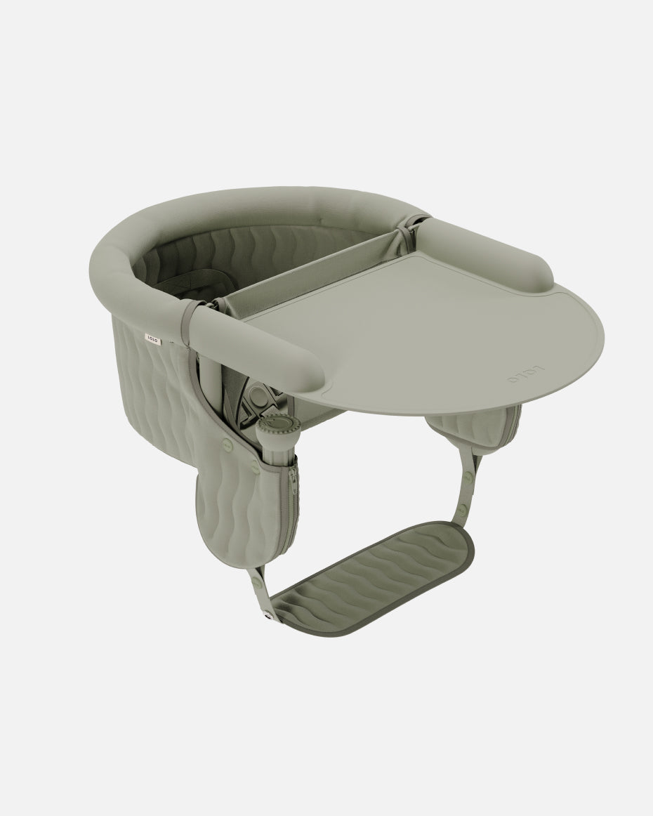 A sage green baby seat with a tray
